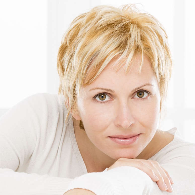 Middle ages woman with blond hair and without wrinkles looking to you.